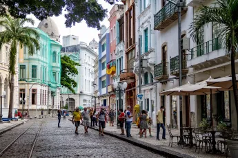 Pessoas caminhando por uma rua cheia de cores em Recife, Brasil.