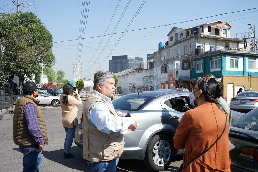 Pessoas conversam em frente de um carro estacionado em Naucalpan, México.