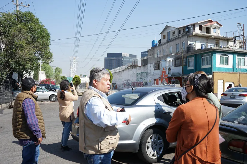 People talk in front of a parked car in Naucalpan, Mexico