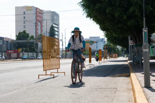 A woman cycles in an empty street.