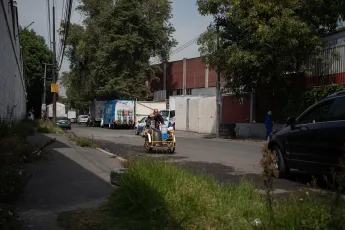 Un vendedor ambulante monta en bicicleta con un niño a su lado.