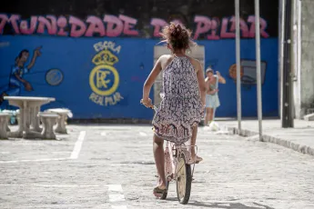Una joven en bicicleta en un entorno urbano.