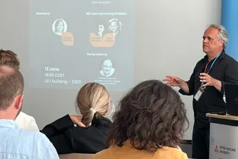 A man gives a talk in front of an audience.