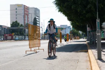 A woman cycles in an empty street.