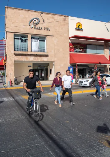 A cyclist and pedestrians cross a street in Léon, Mexico.